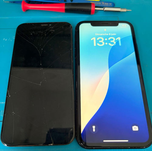 Téléphone allumé à côté de son ancien écran endommagé