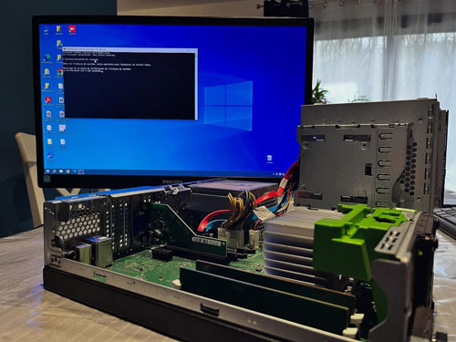 Ordinateur de bureau ouvert sur un établi devant un écran Windows