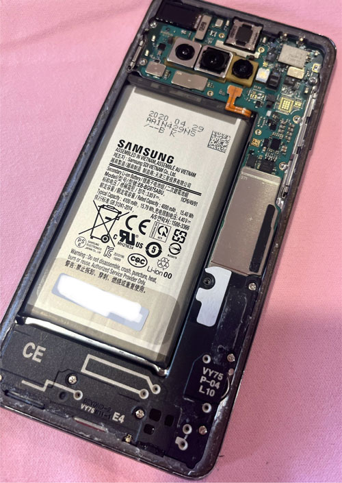 Vue rapprochée de la batterie et de la carte électronique d’un smartphone ouvert