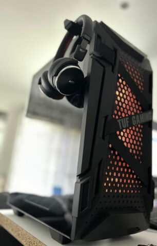 Tour Tuf Gaming avec paroi vitrée et un casque AEG accroché sur son suport